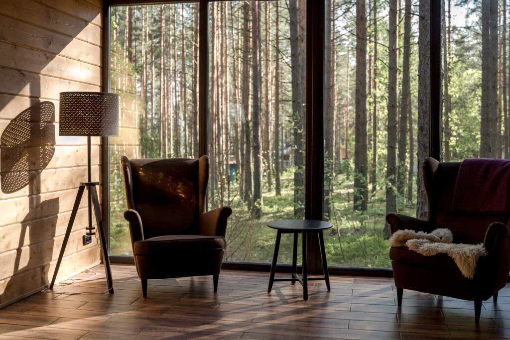 Brown padded armchairs beside the glass window